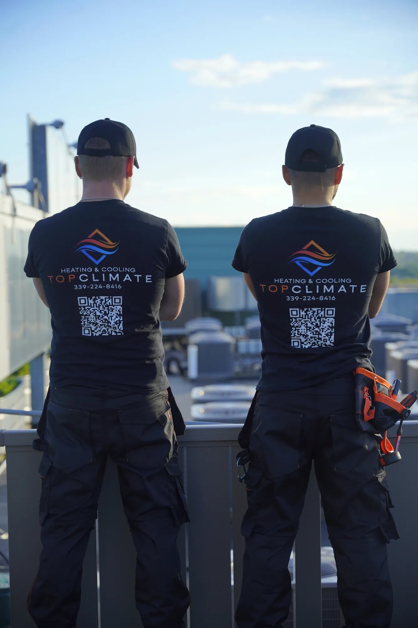 Two Top Climate technicians seen from behind in company shirts