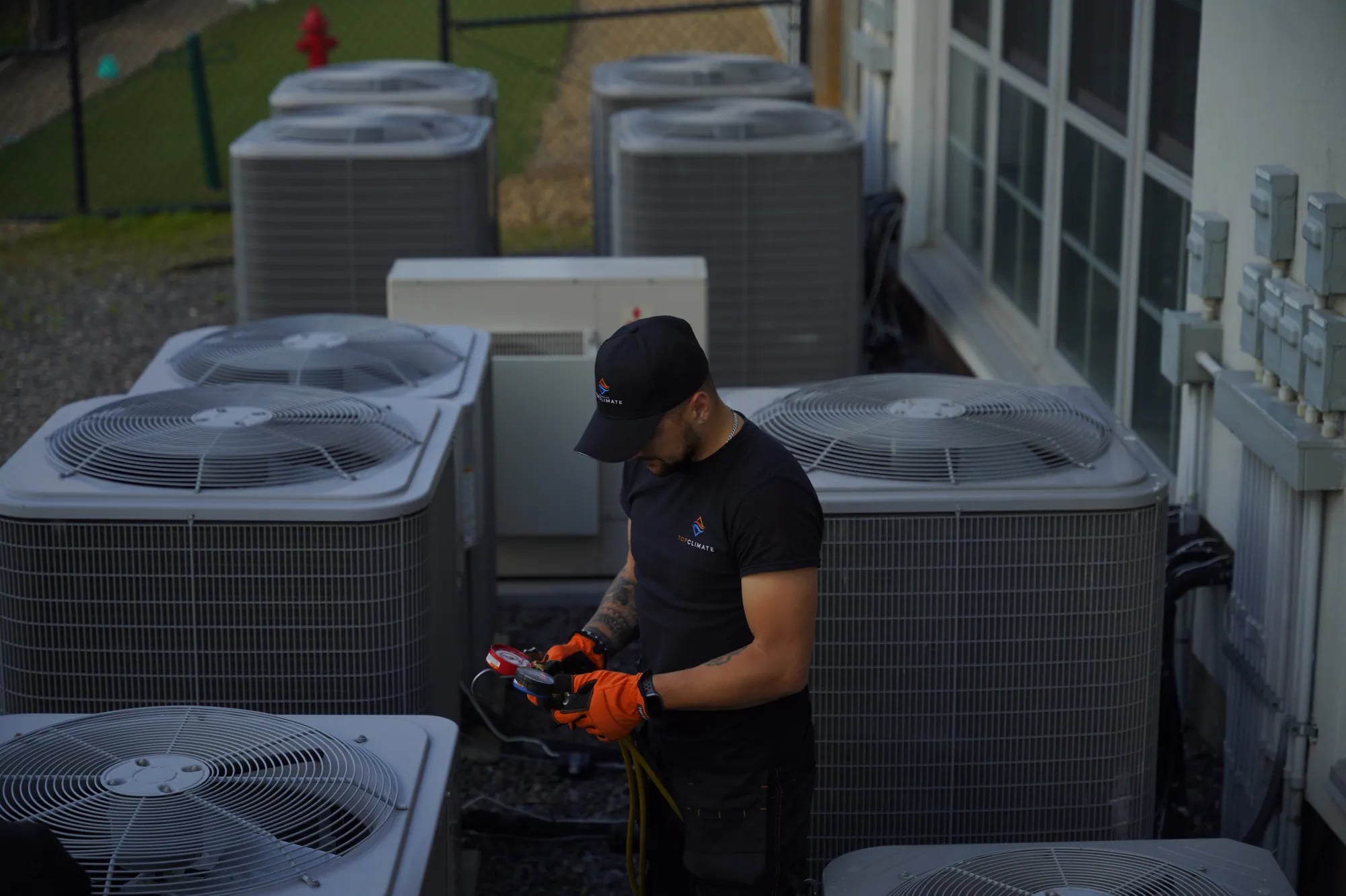 Technician checking a row of outdoor condensing units