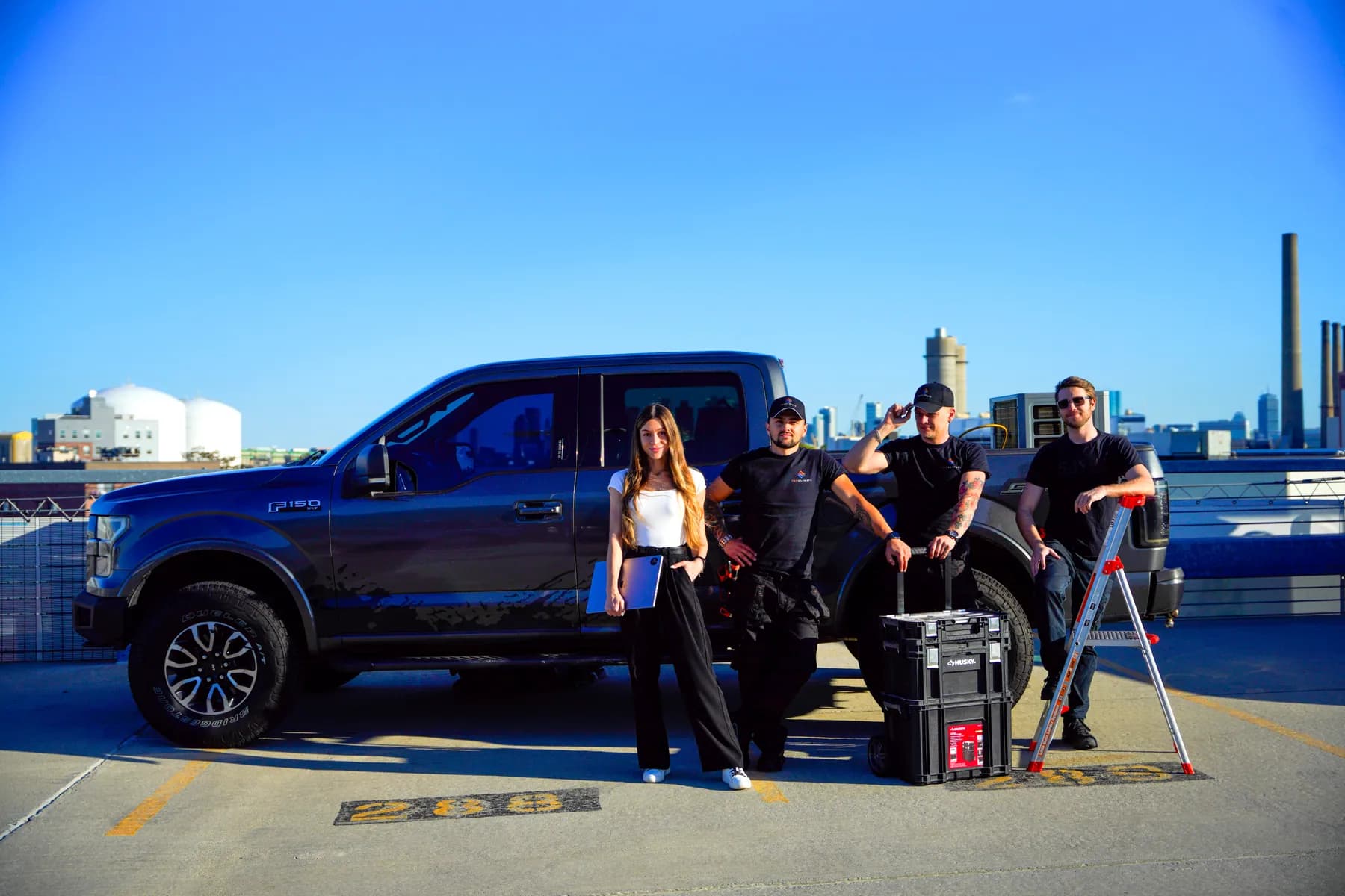 The Top Climate team standing beside their truck on a rooftop